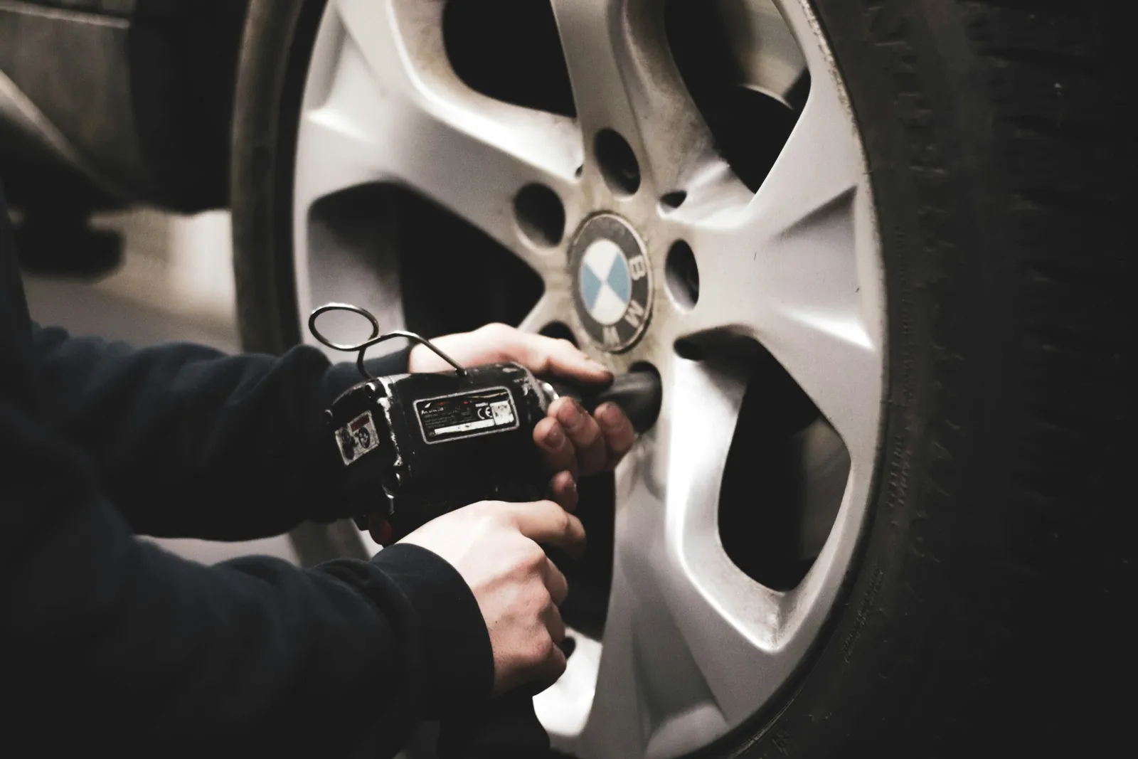 A mechanic unscrewing bolts in a BMW car
